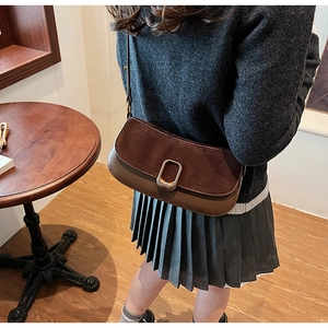 Detail of retro suede and leather patchwork shoulder bag with golden metal lock