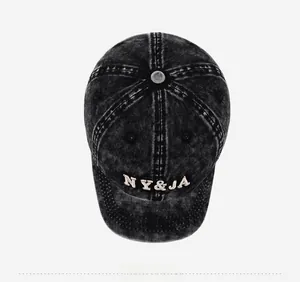 Macro view of washed vintage baseball cap featuring white NY&JA letter embroidery detail