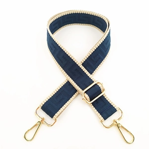 Detail of adjustable blue geometric weave bag strap with golden metal swivel hooks