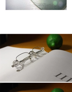 Detailed macro view of square transparent frames with silver metal temples on a book