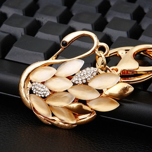Detail of crystal swan keychain with gold metal plating and sparkling yellow rhinestones