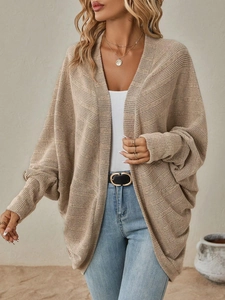 Dettaglio macro del tessuto cardigan in maglia a coste beige e maniche a pipistrello