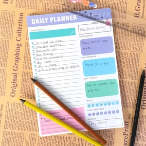 Agenda giornaliera colorata con sezioni per obiettivi su sfondo di carta vintage