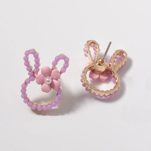 Detail of bunny stud earrings featuring purple beads and a pink matte flower element