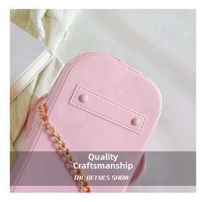 Detailed close-up of pink PVC shell bag with golden metal chain and glossy texture