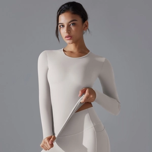 Detailed view of women's long-sleeve yoga top and high-waist leggings in grey