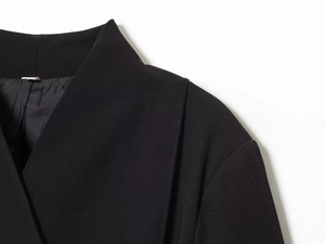 Gros plan détaillé de la texture tissée et des coutures d'un blazer noir chic