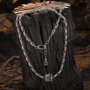 Vintage silver chain necklace with square purple zircon pendant on dark wood background