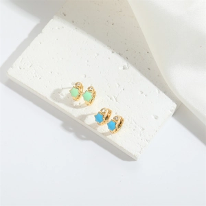Detail of star-shaped enamel earrings with small diamond inlay on gold hoops