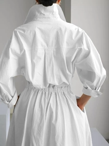 Vue arrière d'une robe chemise blanche à manches longues avec taille cintrée et boutons