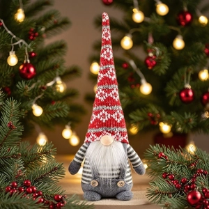Close-up of a Christmas gnome doll with a red snowflake knit hat and grey striped body