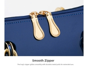 Detail of smooth gold dual zippers on deep blue patent leather boston bag