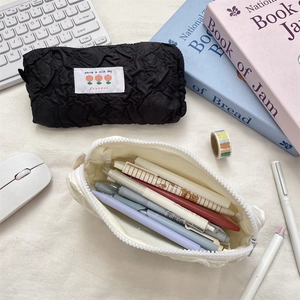 Detail of quilted texture pencil case with 'Have a nice day' label and zipper closure