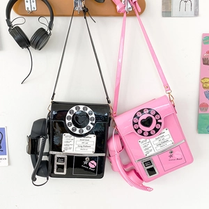 Detail of vintage rotary phone crossbody bags in black and pink with glossy finish