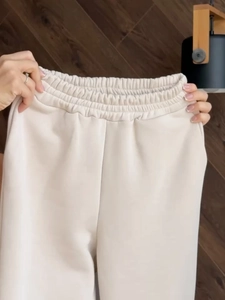 Detailed macro view of the elastic gathered waistband on beige leisure sports sweatpants