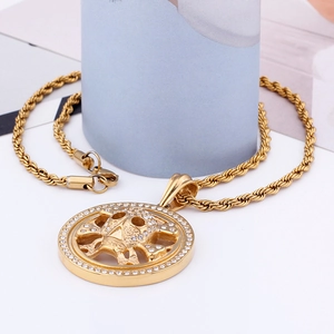 Detailed view of a gold skull pendant with sparkling rhinestones and a twist rope chain