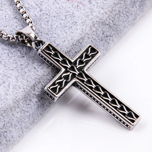 Detailed close-up of a silver-tone cross pendant with intricate woven Celtic patterns