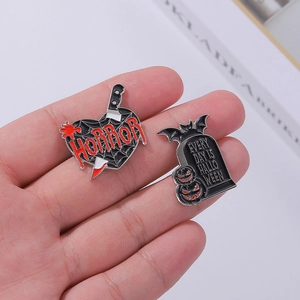 Gothic horror enamel pin set featuring a red heart dagger and a Halloween tombstone badge