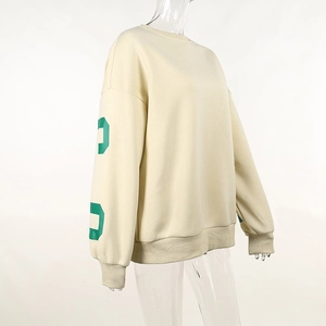 Vue détaillée du sweat-shirt beige oversize avec impression de lettres vertes sur la manche