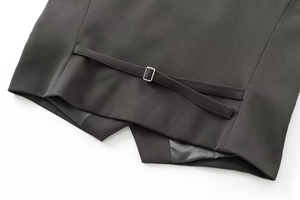 Gros plan du dos d'un gilet de costume noir pour homme avec sangle et boucle en métal