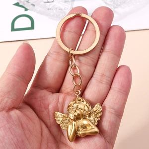 Macro shot of gold angel pendant keychain with detailed wings and metallic ring