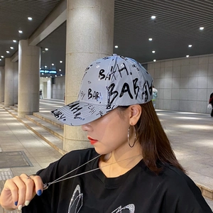 Reflective graffiti baseball cap with printed letters shown in a stylish urban street setting