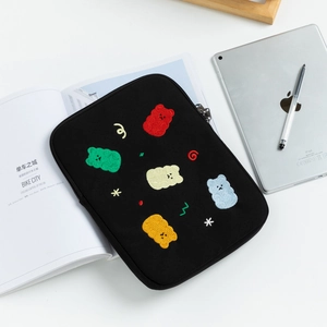 Dettaglio di ricamo con orsetti colorati su custodia nera per laptop con zip