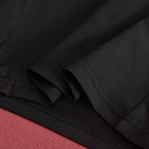 Gros plan sur la texture du tissu noir avec doubles coutures fines et détails de sergé