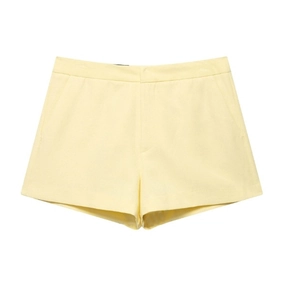 Women's pale yellow button-up vest and high-waisted shorts set on a white background
