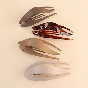 Detailed set of four large matte and glossy duckbill hair clips in neutral earth tones