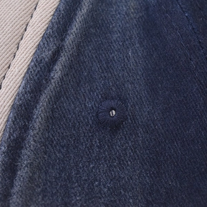 Detailaufnahme von blauem gewaschenem Denim mit gestickten Ösen und feiner Textur