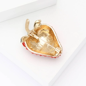 Detail view of the strawberry brooch back with secure pin clasp on gold plated metal