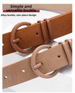 Detail of alloy round buckle on brown leather belts with seamless one-piece molding