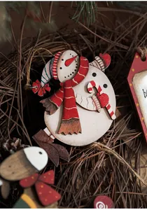 Macro shot of handcrafted wooden snowman ornament with festive scarf on pine needles