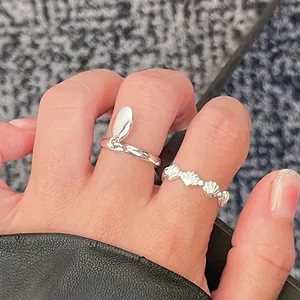 Detail of 925 sterling silver ring set featuring shell texture and leaf charm