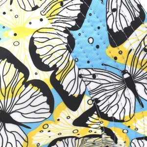 Close-up of the detailed butterfly pattern and precision stitching on the sun hat fabric