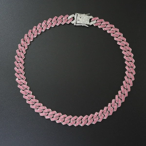 Detail of silver Cuban link necklace with pink and white rhinestones on black background