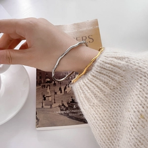 Elegant wavy metallic bangles in gold and silver finish with minimalist organic lines