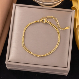 Detailed close-up of double-layer gold titanium steel bracelet with S.STEEL logo tag