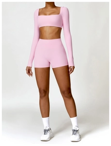 Λεπτομέρεια ροζ μακρυμάνικο crop top και ψηλόμεσο σορτς γυμναστικής σε μοντέλο