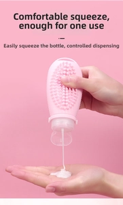 Pink silicone travel bottle showing white lotion dispensing with massage brush detail