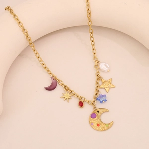 Close-up of golden necklace with colorful star, moon charms and white faux pearl detail