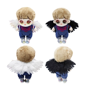 Detail view of cotton doll wearing blue denim overalls and white or black angel wings