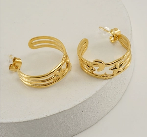 Close-up of wide 18K gold plated stainless steel hoop earrings with star moon cutouts