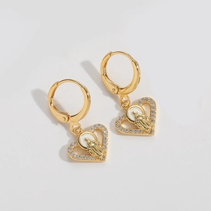 Detailed view of gold heart earrings featuring religious relief and white zircon inlay