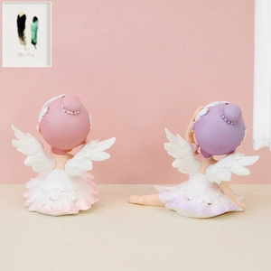 Close-up of pink and purple resin ballet girl ornaments with delicate white angel wings