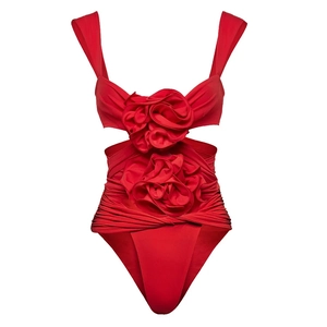 Macro detail of red swimsuit featuring 3D floral appliques and ruched texture fabric