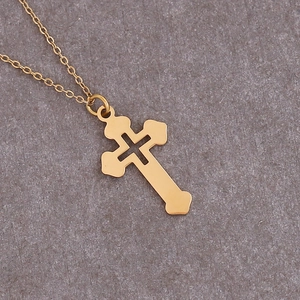 Detail showing a gold-plated stainless steel hollowed cross pendant on a thin link chain