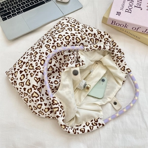 Detail of floral leopard tote bag showing woven handles, inner lining, and zipper pocket