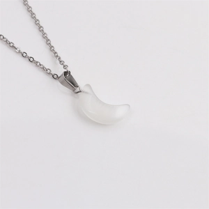 Détail d'une chaîne argentée avec un pendentif lune blanc translucide en opale ou œil de chat